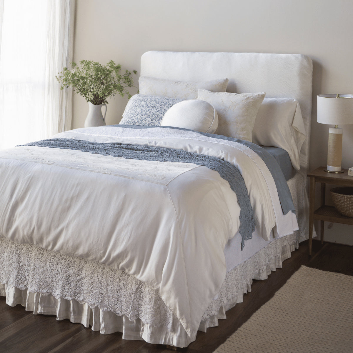 Tahoe Blue: A side view of a bed dressed in Tahoe Blue fitted and flat sheets; Tahoe Blue is a saturated blue like a crystal clear sky.