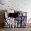 Linen Whisper Crib Skirt | crib skirt and baby comforter from the linen whisper collection on a crib with several pillows and other baby blankets.