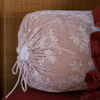 Lynette Throw Pillow | Pearl | a close up of a pink colored embroidered silk velvet bolster pillow.