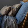 Paloma Pillowcase (Single) | fog colored paloma pillowcaes between a cirillo sham in tahoe blue and taline 15x24 pillow in fog.