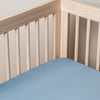 Bria Crib Sheet | Tahoe Blue | Cotton sateen crib sheet shown from a slight overhead angle into  an inside corner of a crib.