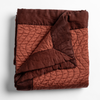 Autumn | A close-up of the corner of a folded Cirillo Blanket in Autumn, a rich terracotta tone, shown against a white background.