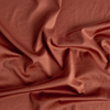 Bria Duvet Cover | Autumn | A close-up of Cotton Sateen fabric gently rumpled in the colorway, Autumn, a rich terracotta tone.