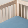 Tahoe Blue | linen crib sheet on the mattress shot slightly overhead into the corner of a white crib. against a white background.