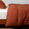 Linen Twin Duvet Cover | Autumn | A close-up side view of a bed with our Linen Duvet Cover and a matching pillowcase in Autumn, a rich terracotta tone.