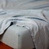 Linen Fitted Sheet | Tahoe Blue | close up of fitted sheet with matching rumpled flat sheet - corner view.