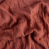 Linen Whisper Crib Skirt | Autumn | A close-up of Linen Whisper fabric in the colorway, Autumn, a rich terracotta tone.