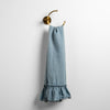 Linen Whisper Guest Towel | Tahoe Blue | guest towel draped through a decorative brass towel ring, against a white wall.