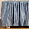 Paloma Crib Skirt | Tahoe Blue | charmeuse crib skirt shown on a white crib against a white wall and medium wood floor.